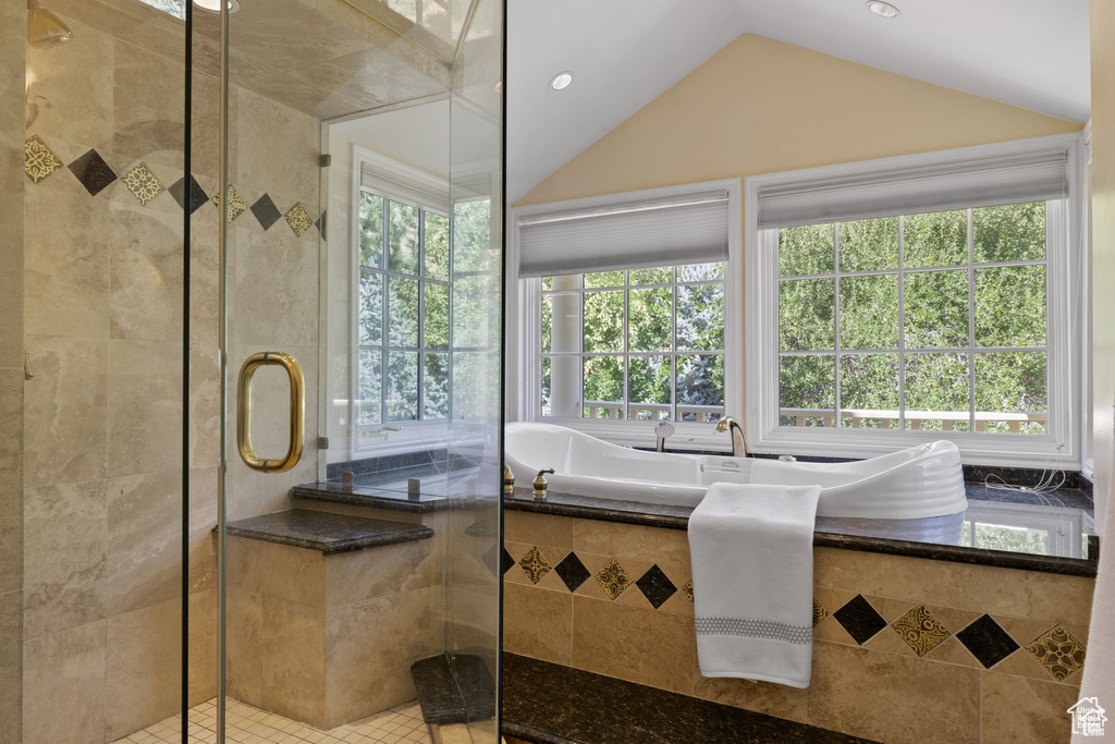 Bathroom with plenty of natural light, a stall shower, vaulted ceiling, tile patterned flooring, and recessed lighting