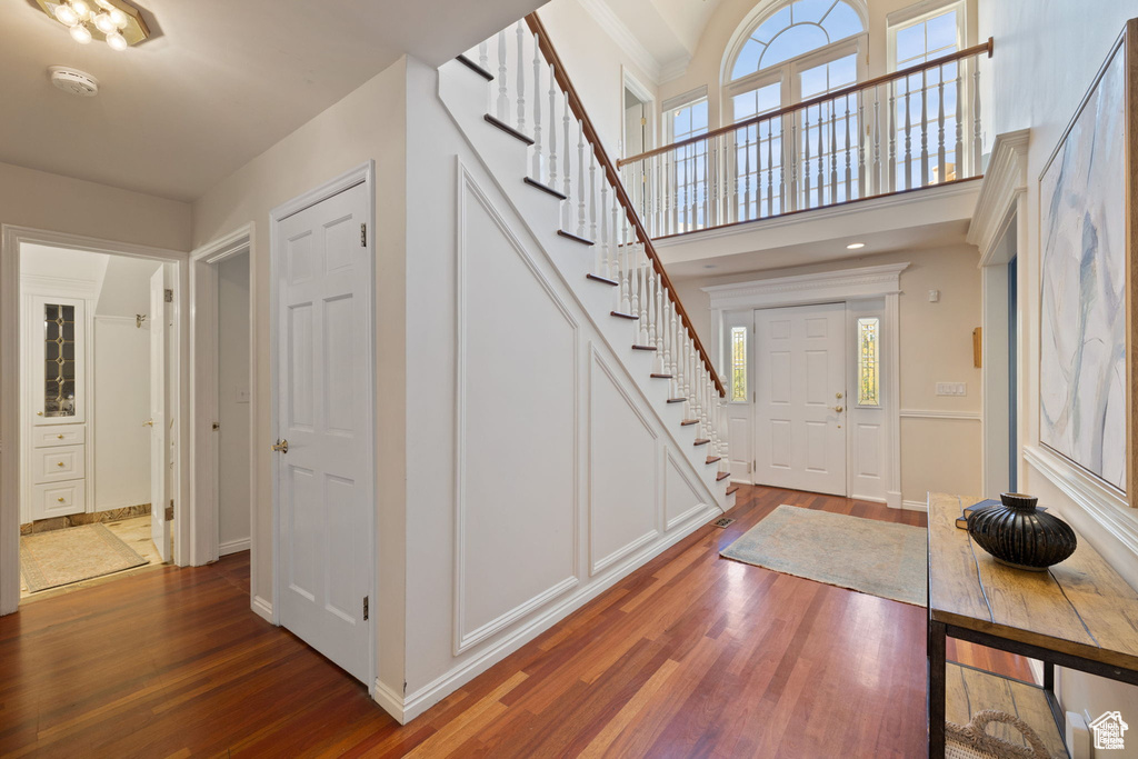 Foyer entrance featuring stairs, wood finished floors, and baseboards