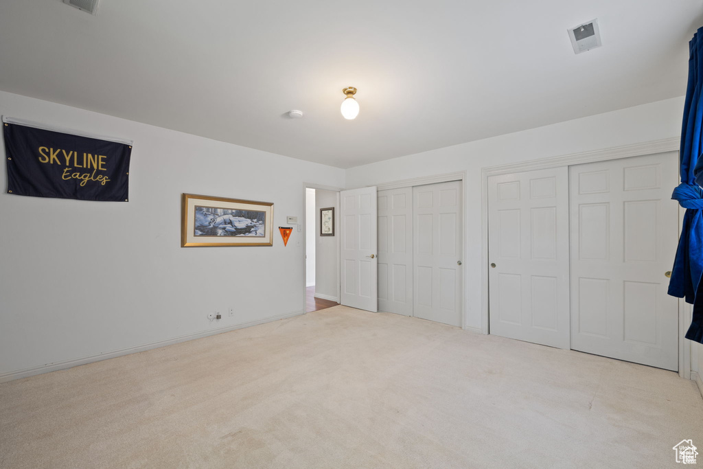 Unfurnished bedroom featuring multiple closets and carpet