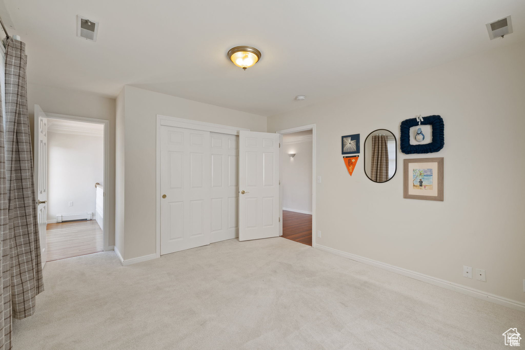 Unfurnished bedroom featuring carpet, baseboards, and a closet