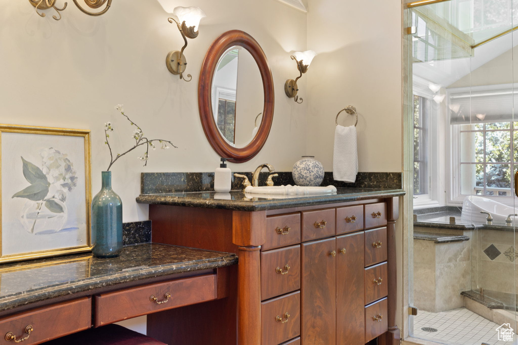 Full bathroom featuring vanity, a tile shower, and lofted ceiling