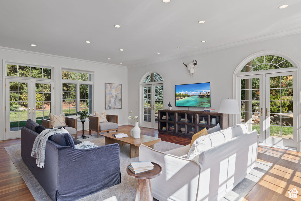 Living area featuring french doors, crown molding, wood finished floors, and recessed lighting