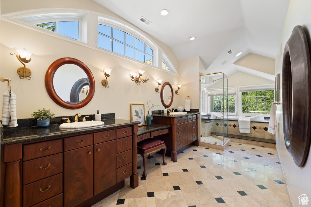 Bathroom featuring lofted ceiling, two vanities, a shower stall, and recessed lighting
