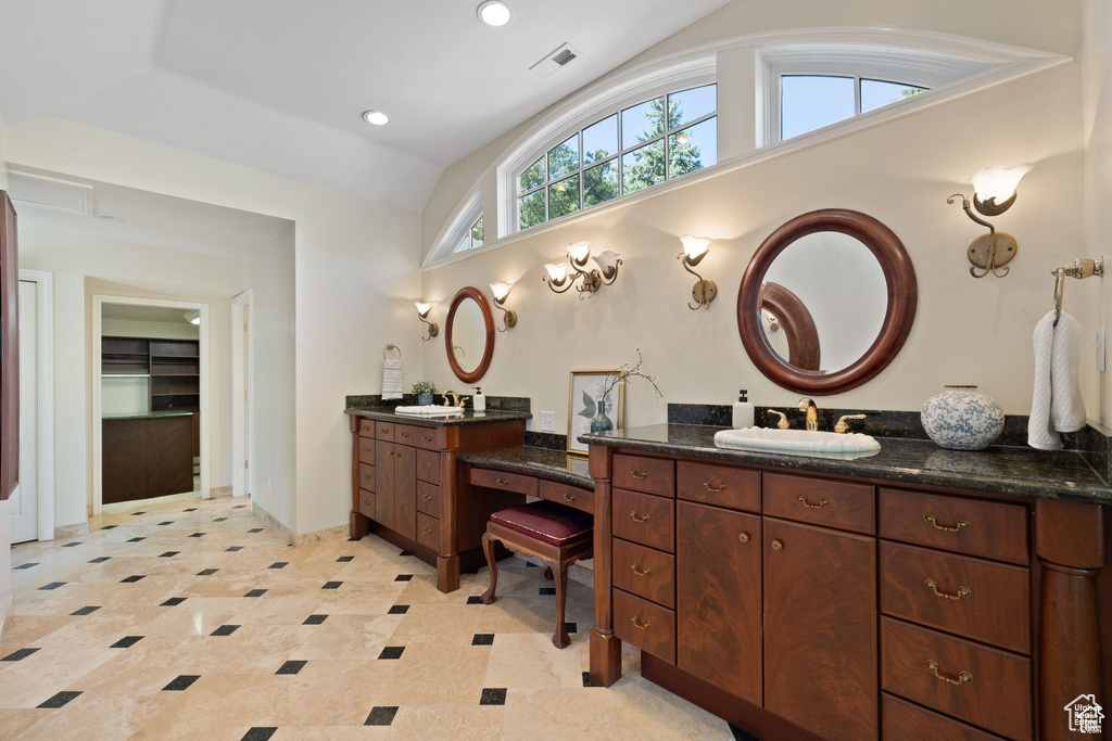 Bathroom with vaulted ceiling, two vanities, and recessed lighting