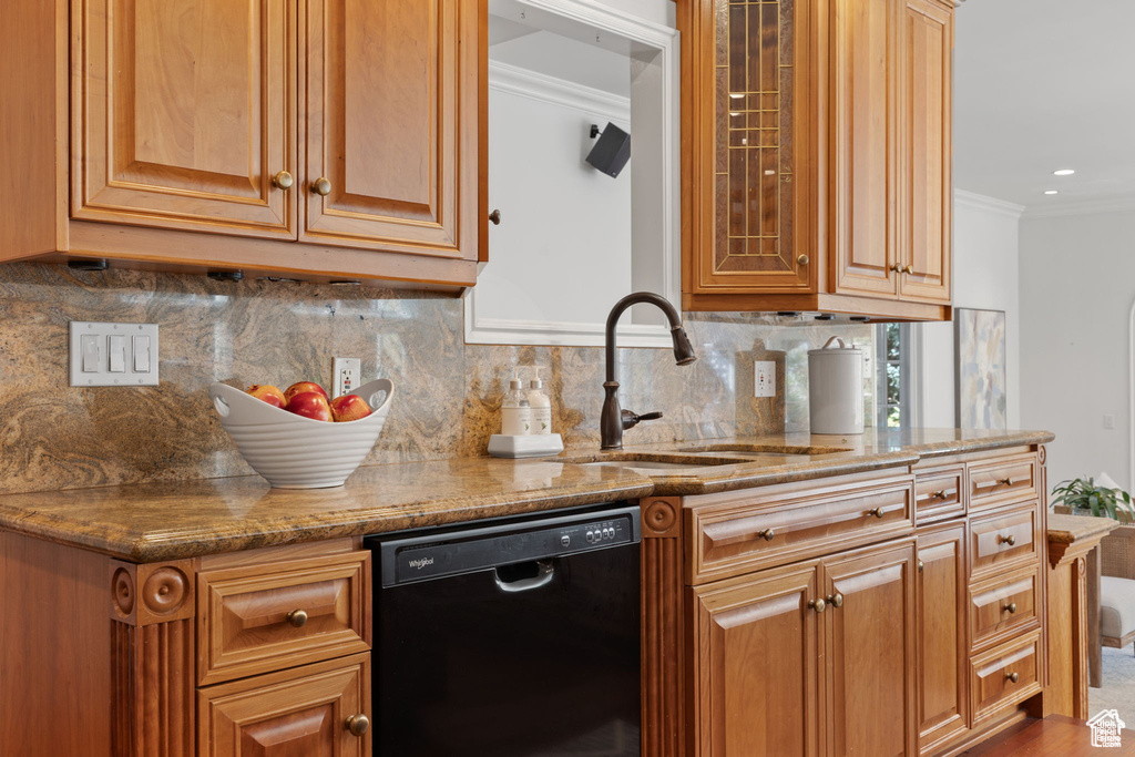 Kitchen with dishwasher, a sink, crown molding, light stone counters, and decorative backsplash