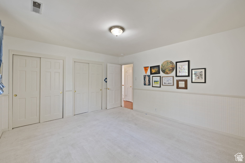 Unfurnished bedroom featuring two closets and carpet floors