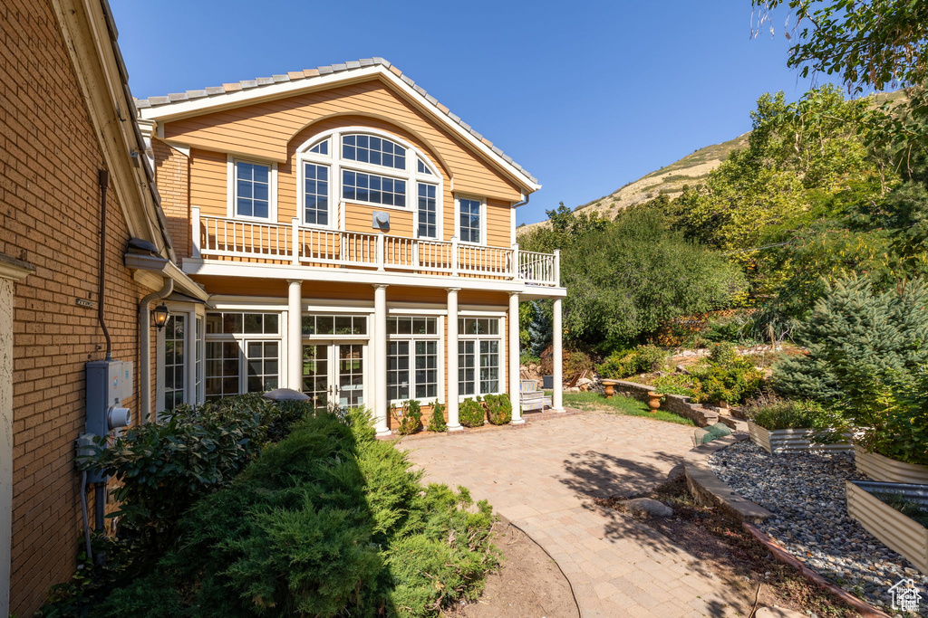 Rear view of property with a balcony and a mountain view