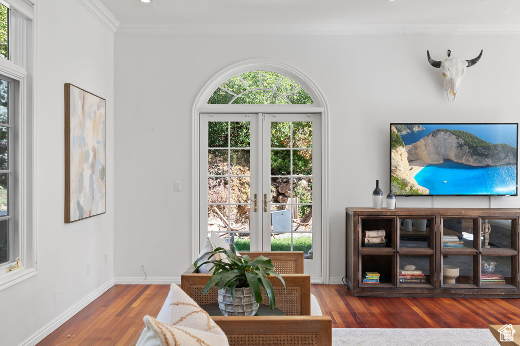 Living area with crown molding, wood finished floors, and baseboards