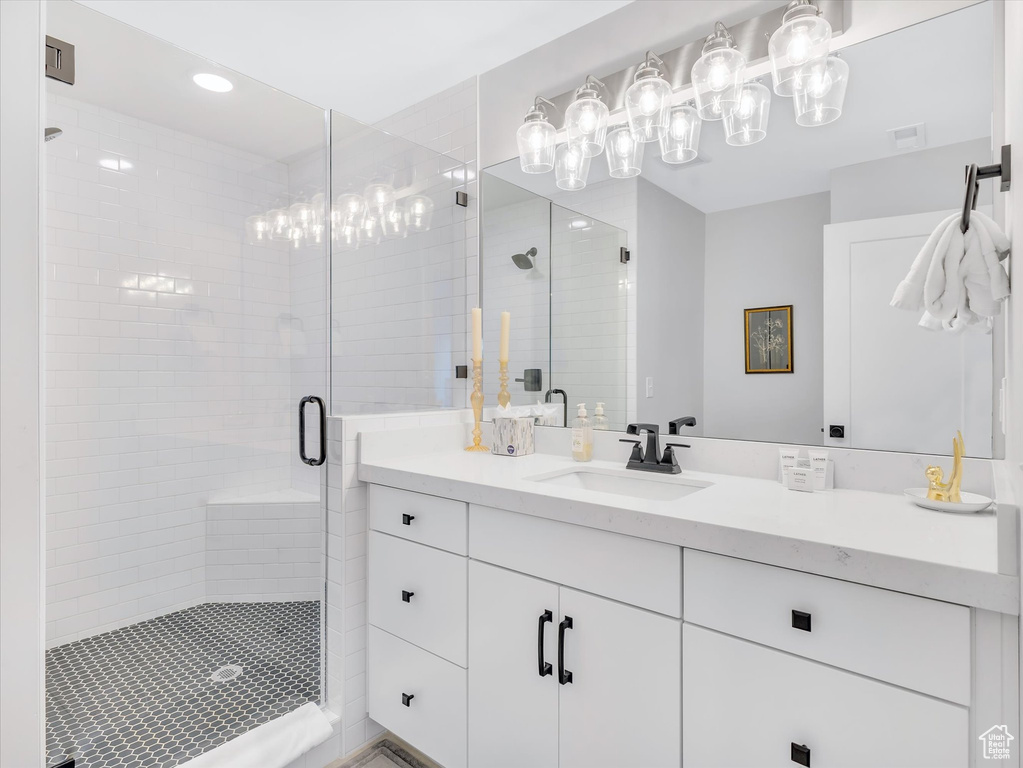 Bathroom featuring a stall shower, vanity, a chandelier, and recessed lighting