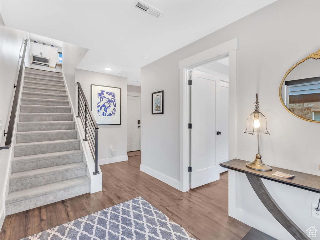Stairway featuring wood finished floors, baseboards, and recessed lighting