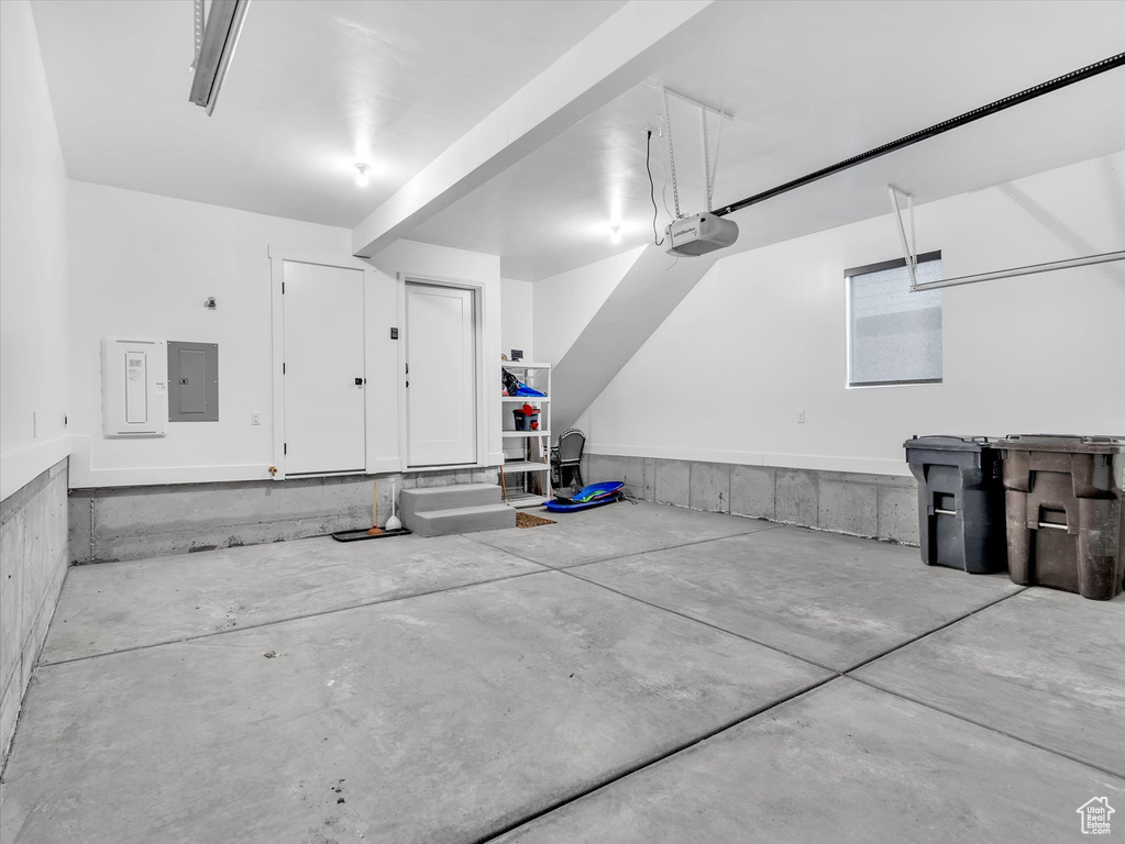 Garage featuring a garage door opener and electric panel
