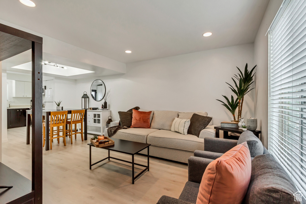 Living area with plenty of natural light, light wood finished floors, and recessed lighting