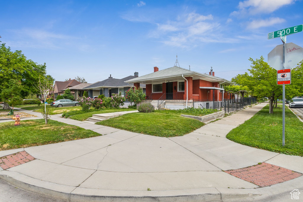 Bungalow-style home with a front lawn and brick siding