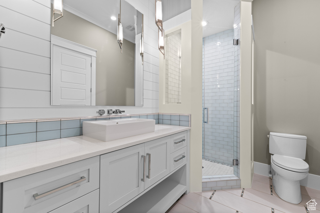 Bathroom with a shower stall, toilet, vanity, tile patterned flooring, and recessed lighting