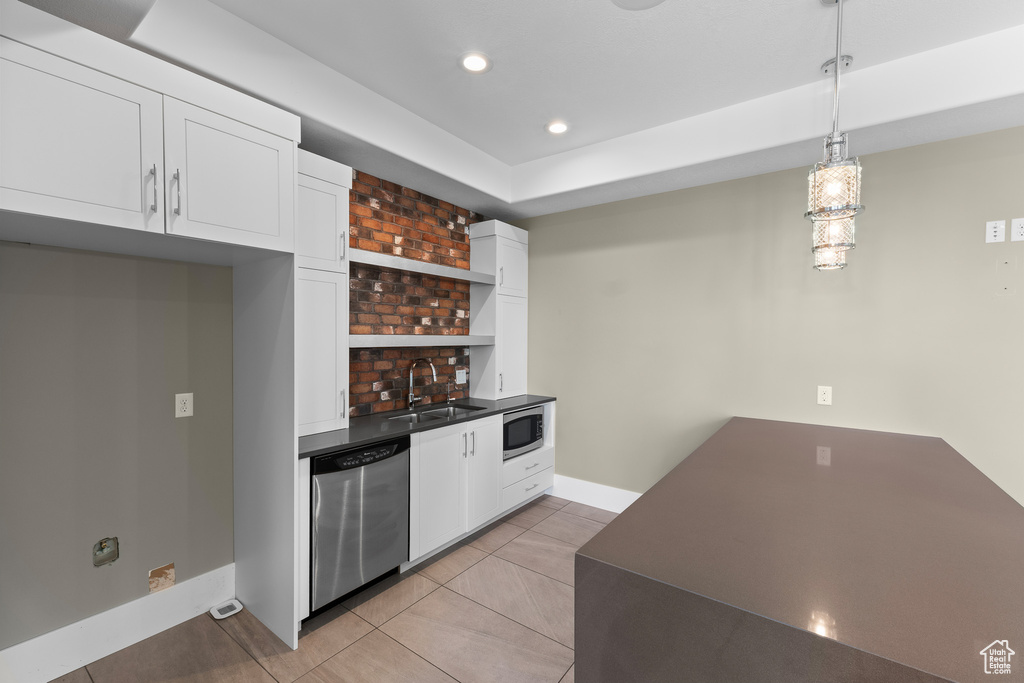 Bar area featuring appliances with stainless steel finishes, a sink, baseboards, light tile patterned floors, and recessed lighting