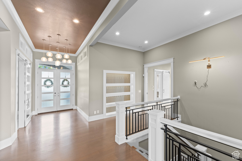Foyer entrance with wood finished floors, recessed lighting, french doors, crown molding, and baseboards