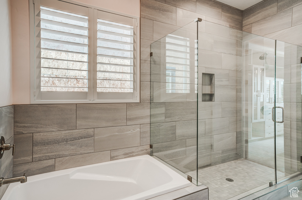 Full bathroom with a bath, healthy amount of natural light, and a stall shower
