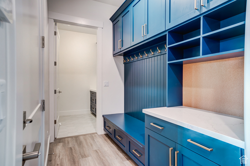 Mudroom with light wood-style floors and baseboards