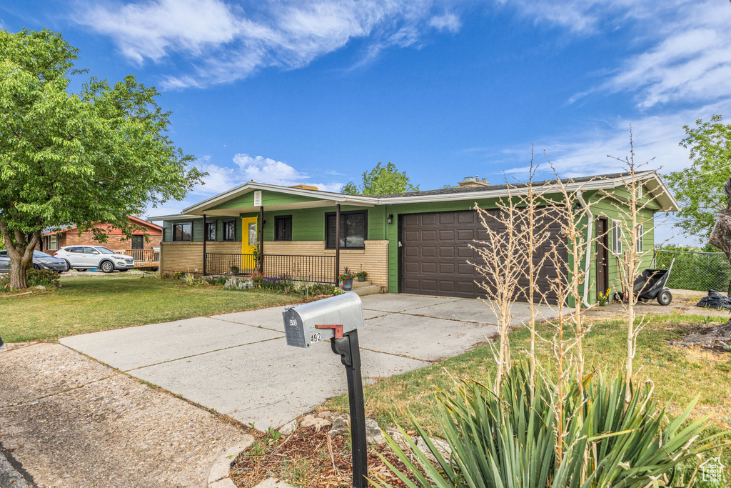 View of front of house featuring an attached garage, a front yard, brick siding, and concrete driveway
