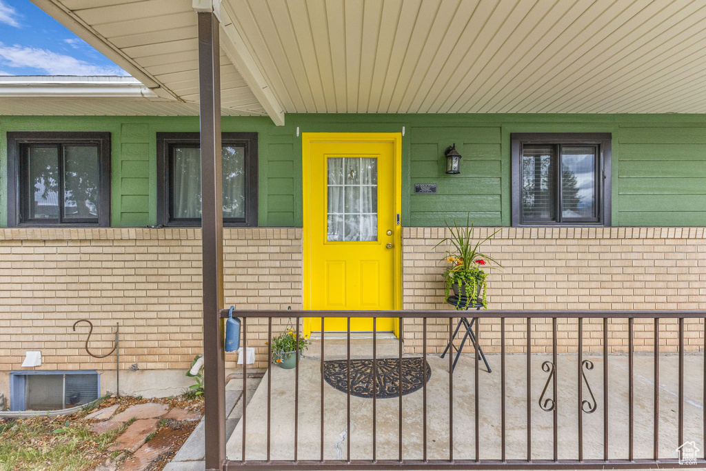 Doorway to property featuring brick siding