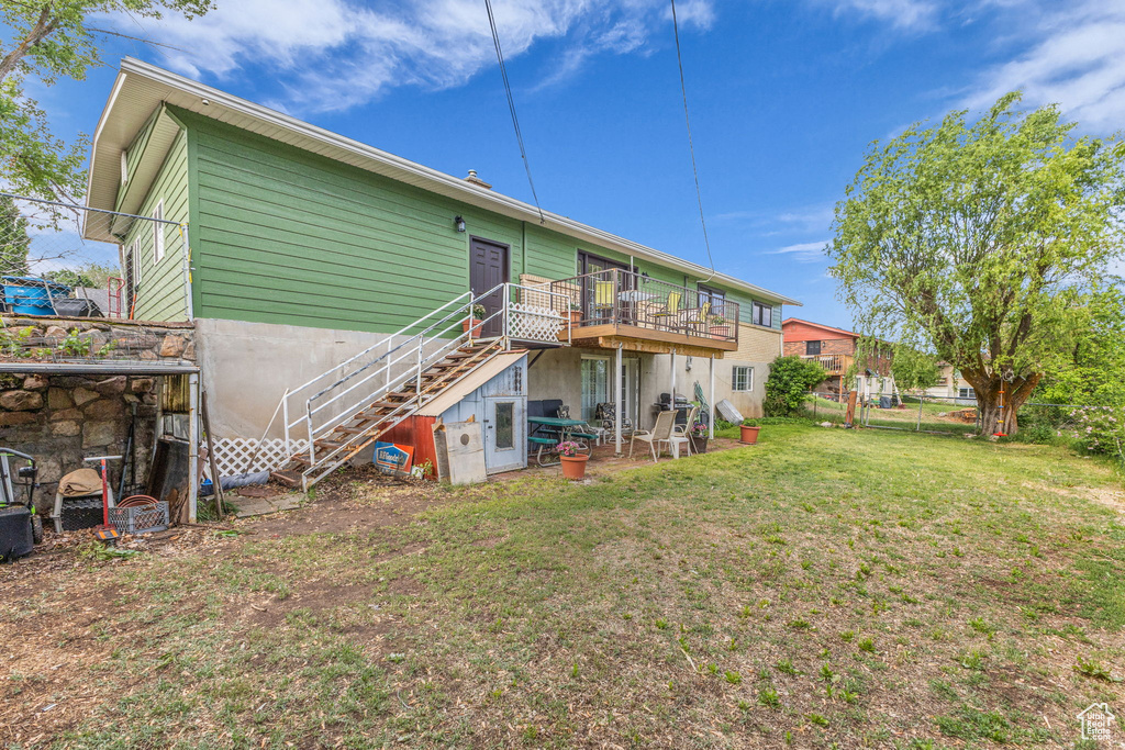 Rear view of house featuring stairs and a deck