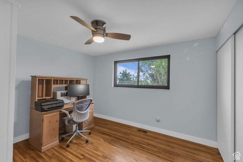 Home office with ceiling fan, baseboards, and wood finished floors