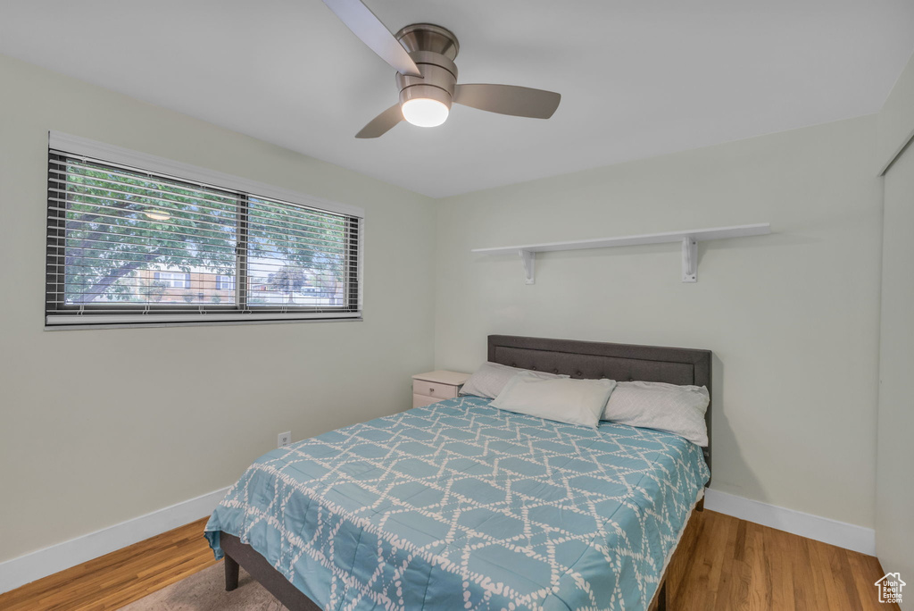 Bedroom with baseboards, wood finished floors, and a ceiling fan