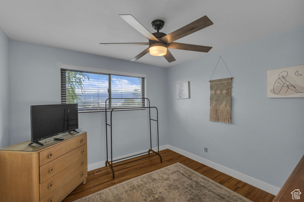 Bedroom featuring baseboards, dark wood finished floors, and ceiling fan