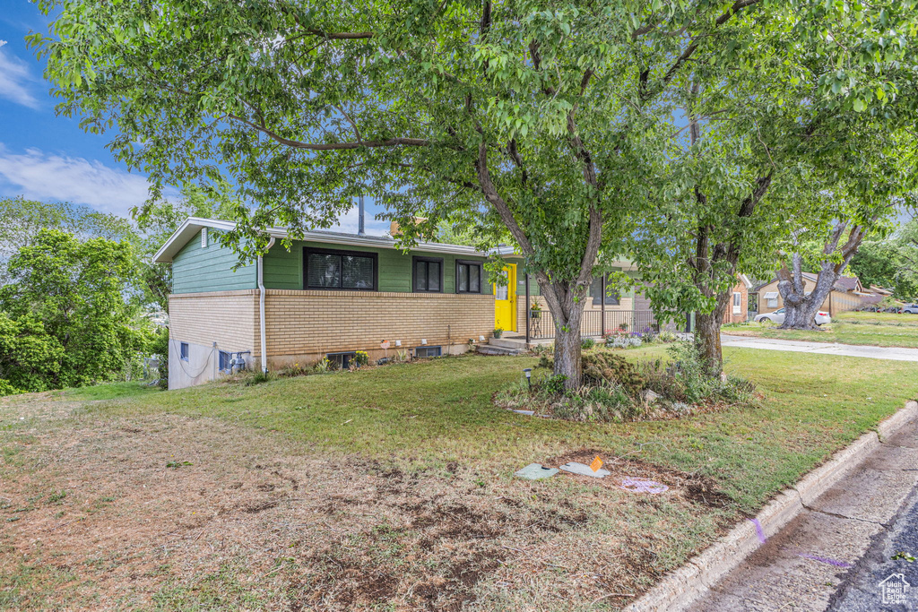 Single story home featuring brick siding and a front yard