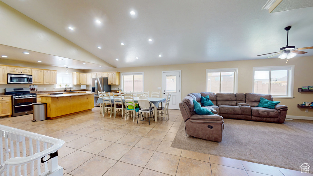 Living area with light tile patterned flooring, recessed lighting, a ceiling fan, plenty of natural light, and lofted ceiling