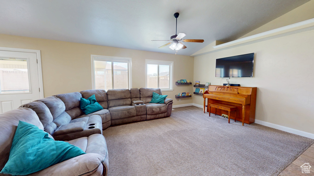 Living room featuring ceiling fan, vaulted ceiling, and baseboards