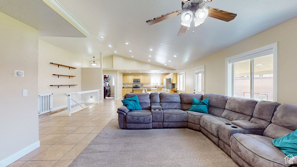 Living room featuring light tile patterned floors, recessed lighting, a ceiling fan, lofted ceiling, and baseboards