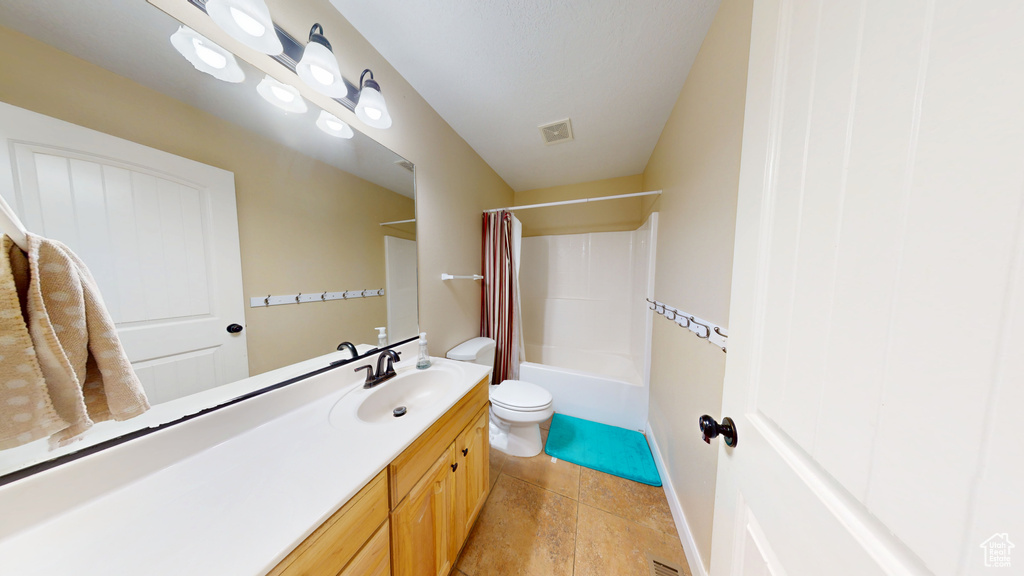 Bathroom with vanity, toilet, and shower / bath combination with curtain