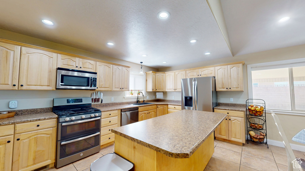 Kitchen featuring appliances with stainless steel finishes, light brown cabinetry, a sink, a kitchen island, and recessed lighting