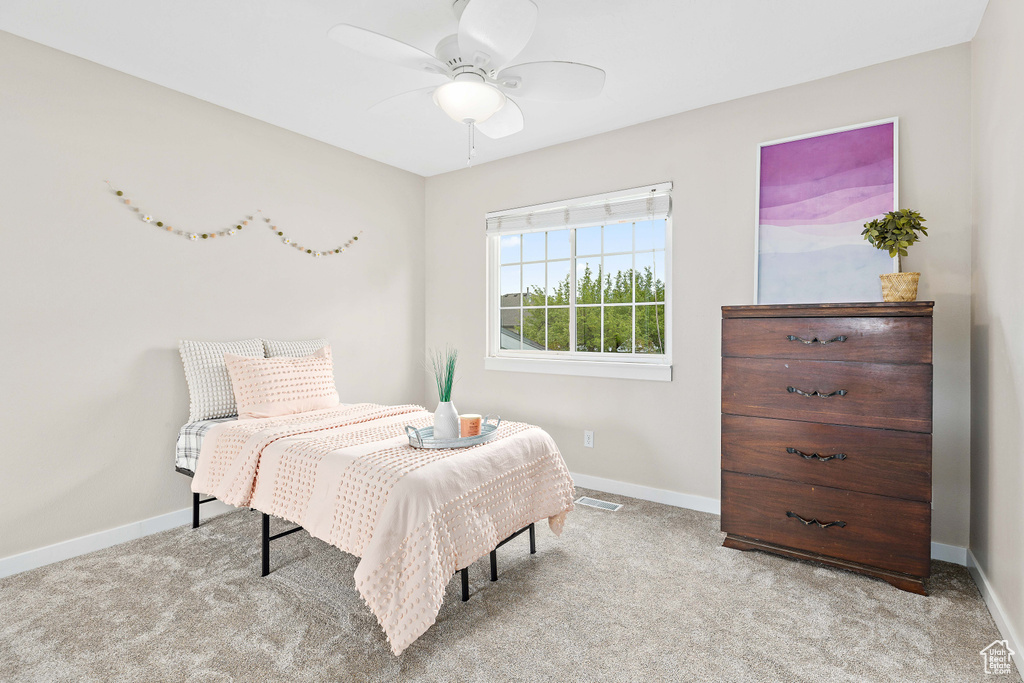 Carpeted bedroom featuring baseboards and ceiling fan