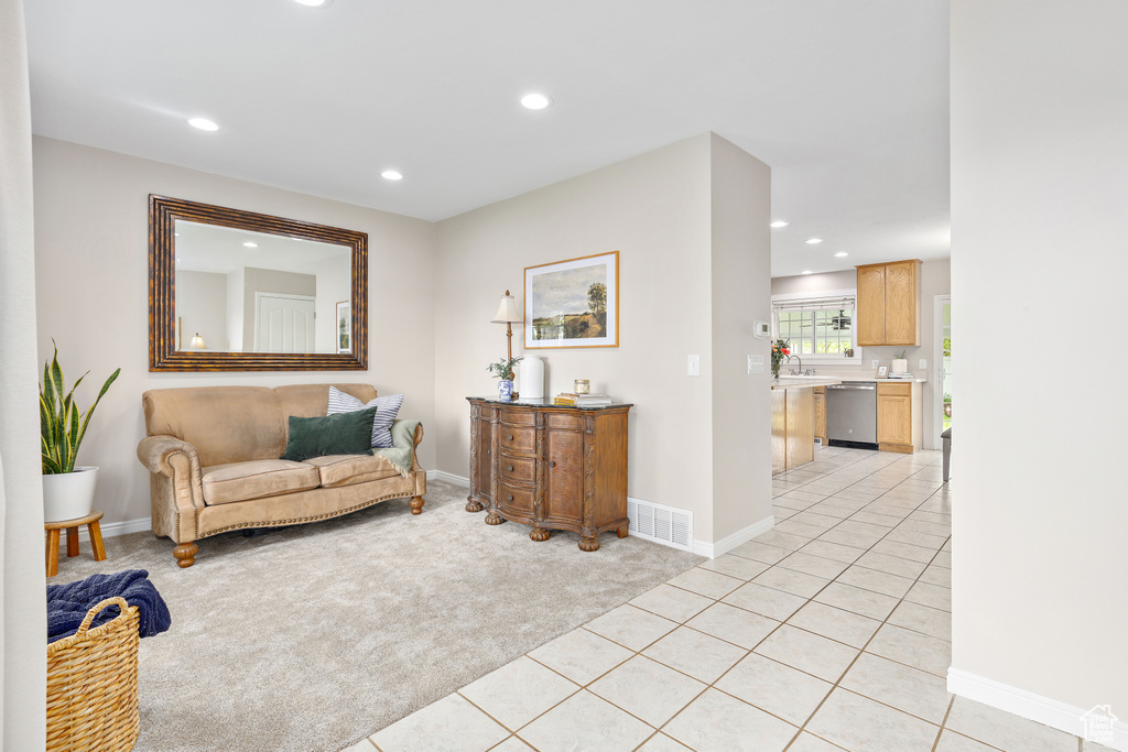 Living area featuring light colored carpet, recessed lighting, baseboards, and light tile patterned flooring