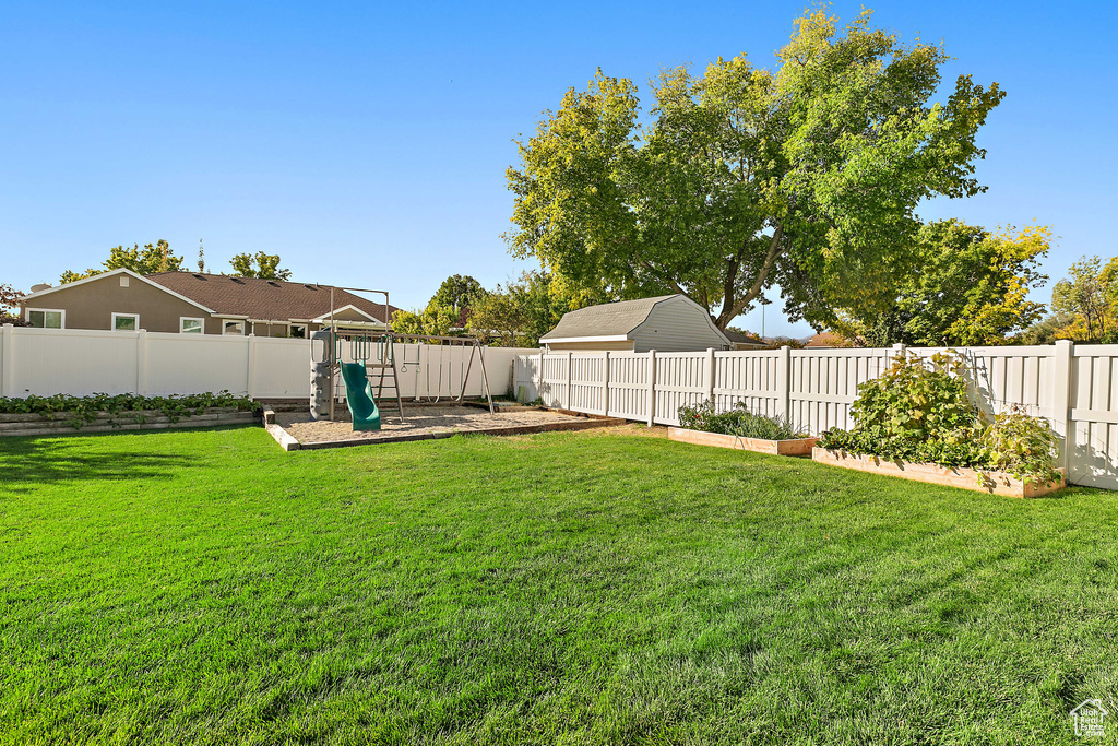 View of yard featuring a playground and a vegetable garden