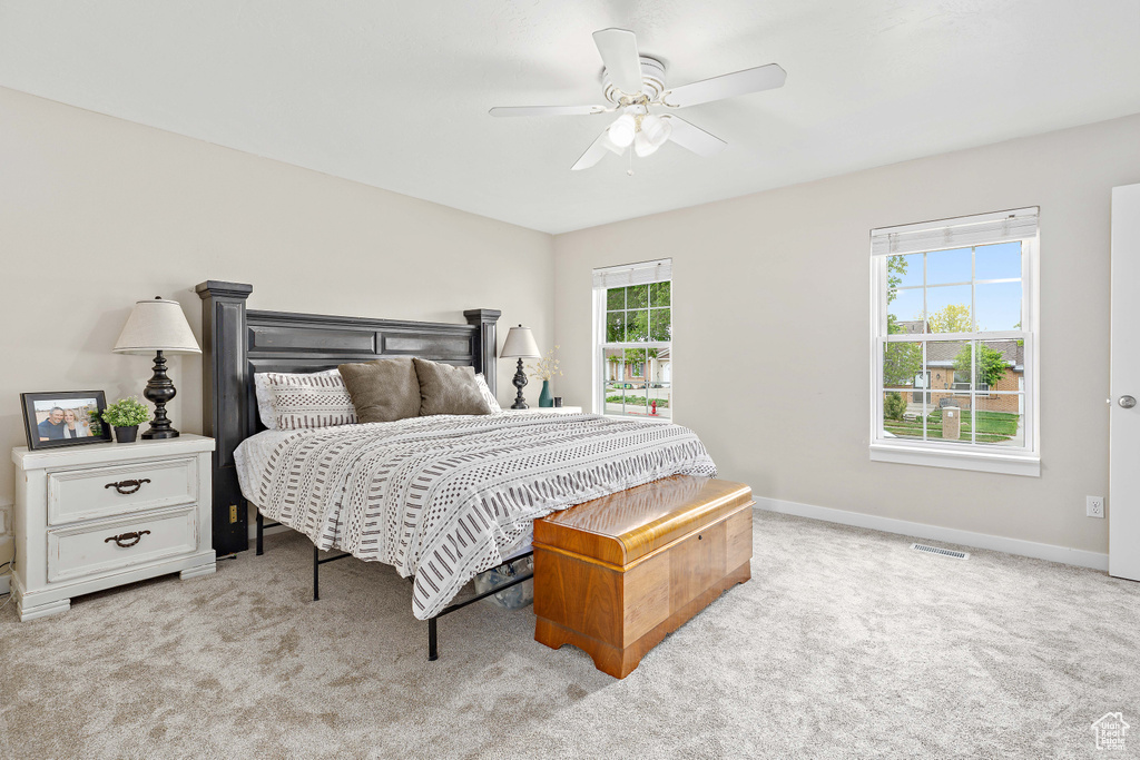 Bedroom with light carpet, baseboards, and ceiling fan