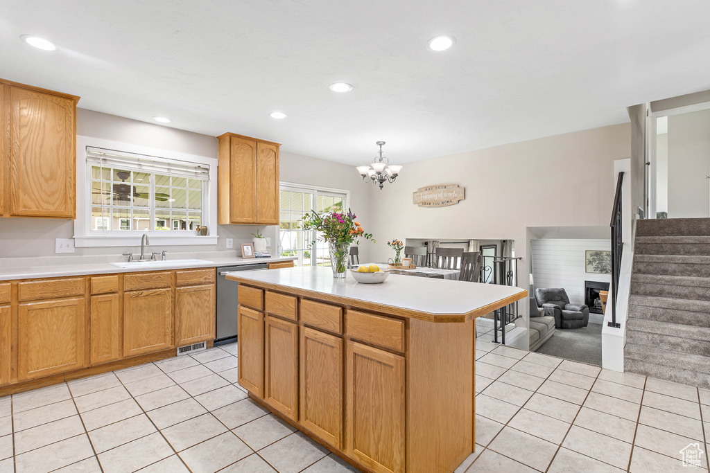 Kitchen with stainless steel dishwasher, light tile patterned flooring, a sink, light countertops, and recessed lighting