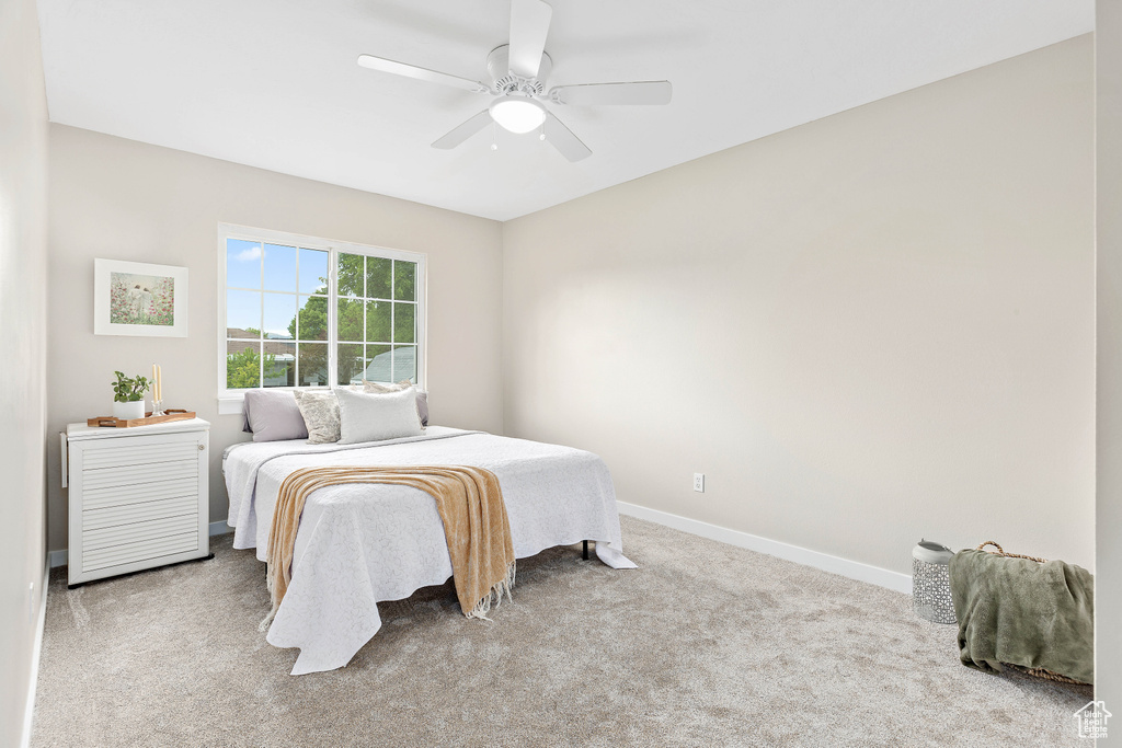 Carpeted bedroom with baseboards and ceiling fan
