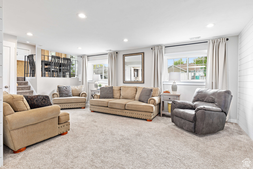 Living area featuring carpet floors, recessed lighting, and stairway