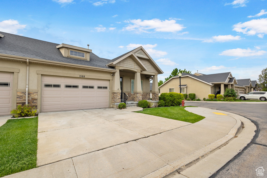 Craftsman house with stone siding, driveway, stucco siding, and a porch