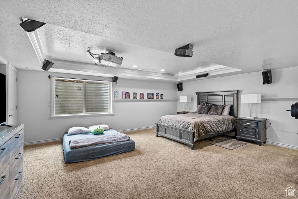 Bedroom featuring a raised ceiling, a textured ceiling, carpet flooring, baseboards, and recessed lighting