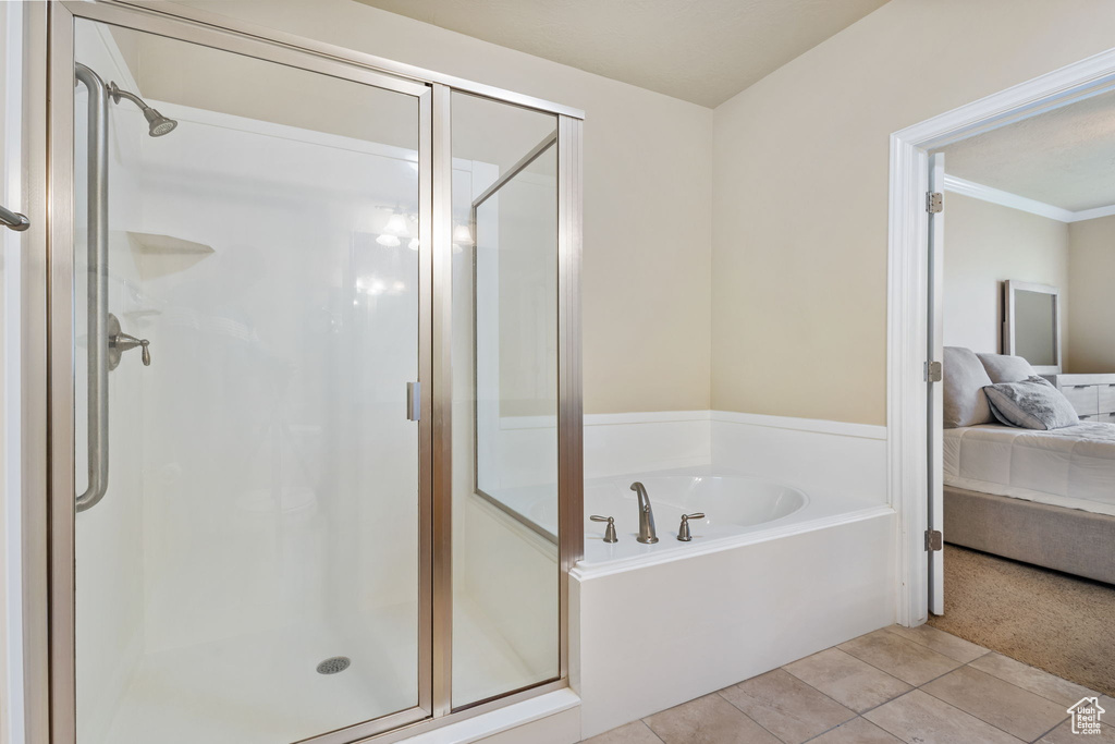 Full bath featuring connected bathroom, a shower stall, a garden tub, tile patterned flooring, and crown molding