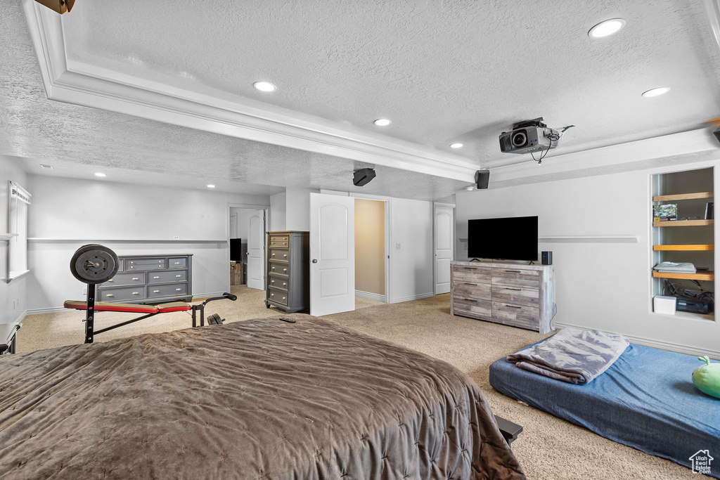 Bedroom with a textured ceiling, light colored carpet, baseboards, recessed lighting, and a tray ceiling