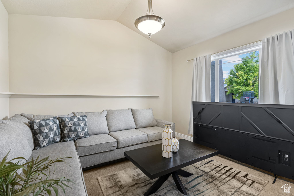 Carpeted living area featuring lofted ceiling