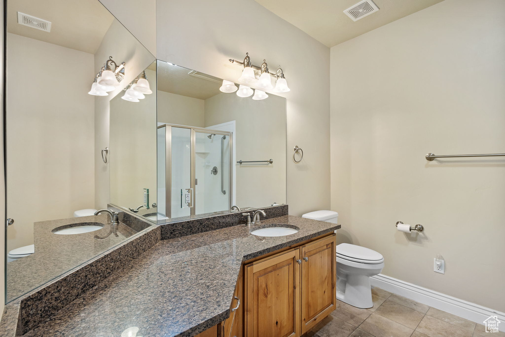 Full bath featuring toilet, a stall shower, vanity, tile patterned floors, and baseboards