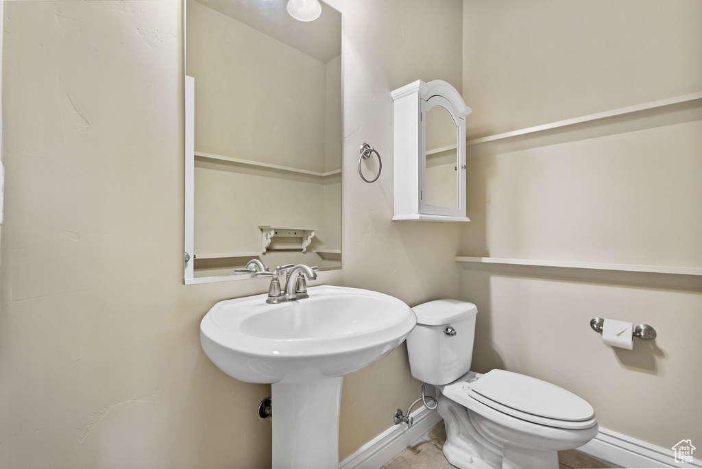 Bathroom with toilet, a sink, and baseboards
