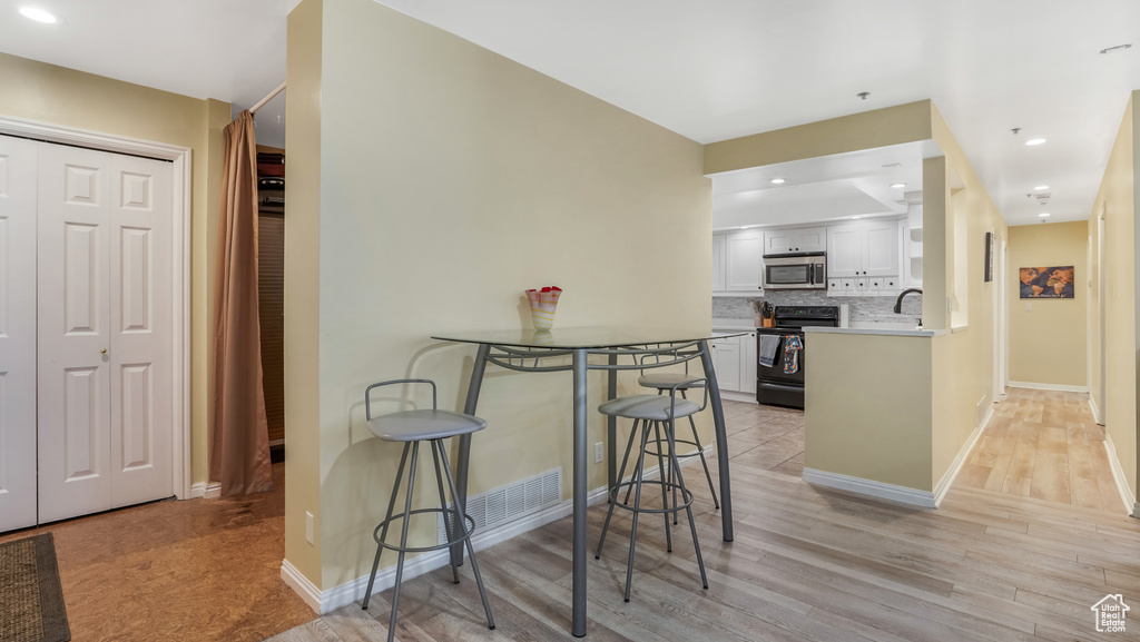 Dining space featuring light wood-style floors, baseboards, and recessed lighting
