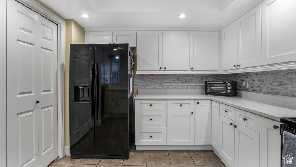 Kitchen featuring black appliances, white cabinetry, light countertops, recessed lighting, and light tile patterned flooring